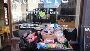 Kuva From Waste to Taste- konseptin ikkunasta. Kuvassa näkyy ikkunan edessä olevia leipäpusseja.